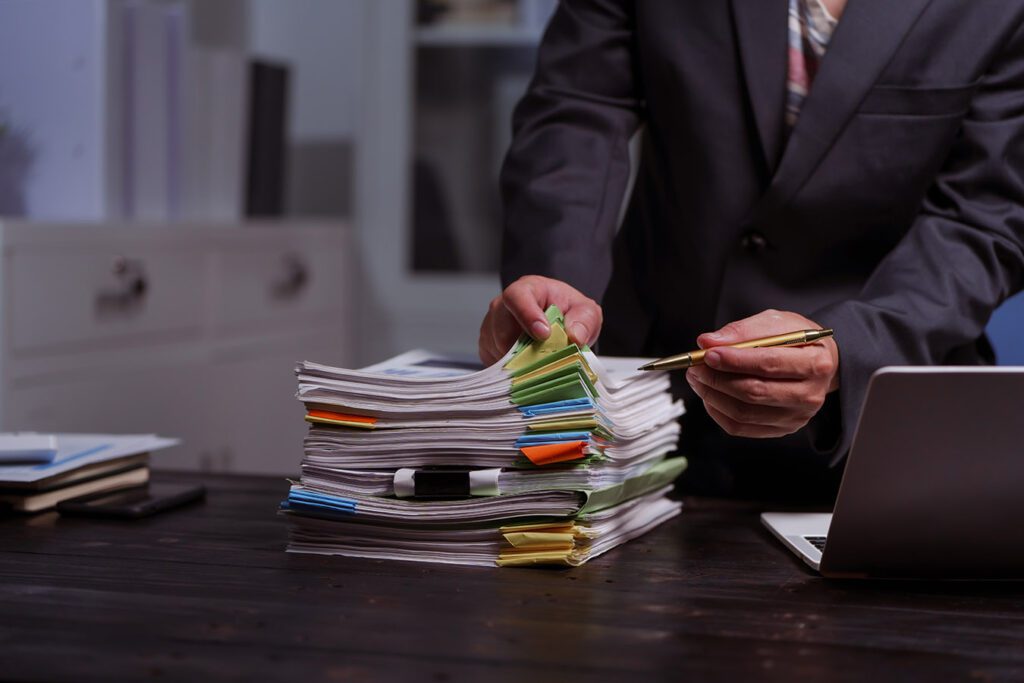 professional-reviewing-a-stack-of-overdue-invoices-for-collection
