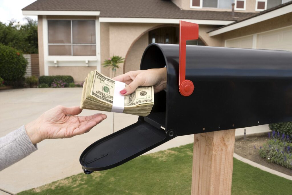 handing money stack out of the mailbox